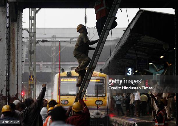 Repair work underway as overhead wire snapped near Dadar railway station on June 23, 2015 in Mumbai, India. Trains on western line are delayed by 15...