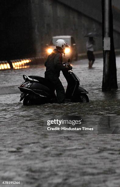 Bike pass through a flooded street after heavy rain at Hindamata, Dadar on June 23, 2015 in Mumbai, India. Heavy rainfall across Mumbai city and...