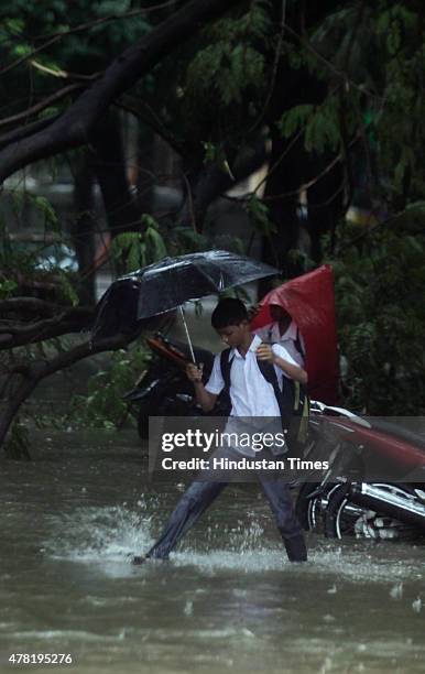 School boy walks through a flooded street after heavy rain at Parel on June 23, 2015 in Mumbai, India. Heavy rainfall across Mumbai city and suburban...