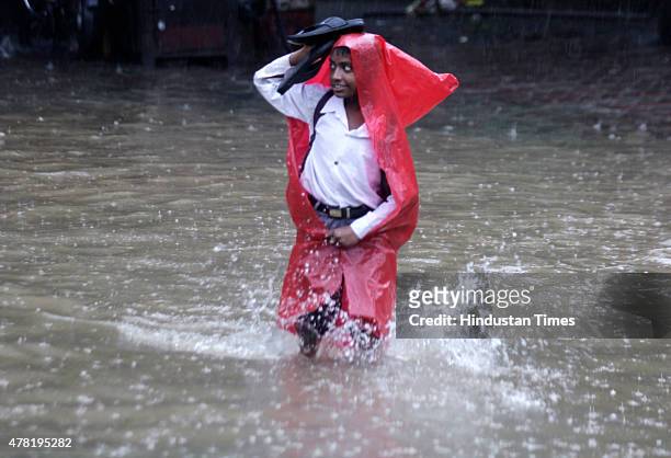 School boy walks through a flooded street after heavy rain at Parel on June 23, 2015 in Mumbai, India. Heavy rainfall across Mumbai city and suburban...