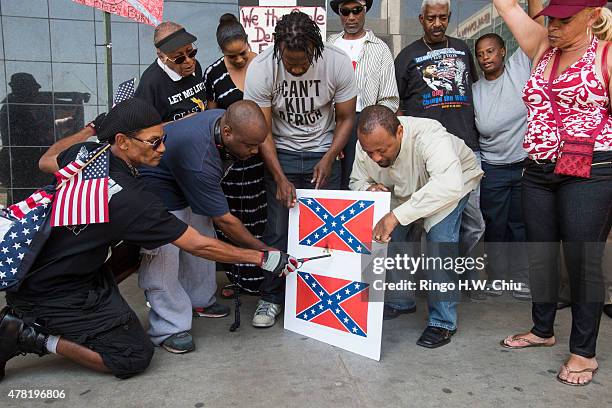 Protesters burn paper Confederate flags during a rally on June 23, 2015 in Los Angeles, California. The protesters were supporting the call by South...