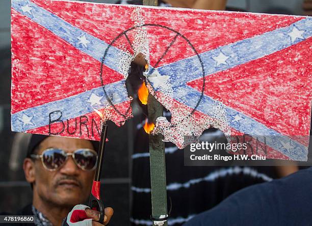 Protesters burn a paper Confederate flag during a rally on June 23, 2015 in Los Angeles, California. The protesters were supporting the call by South...