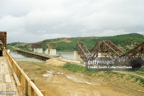 During the Korean war, the wreckage of the original Freedom Gate bridge over the Imjin River entering the Demilitarized Zone , the temporary causeway...