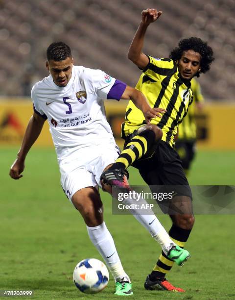 Saudi Arbia's Al-Ittihad Abdullrahman al-Ghamdi fights for the ball with UAE's Al-Ain Ismail Ahmed during their AFC Champions League football match...