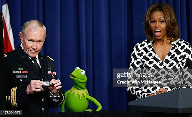 First lady Michelle Obama looks on as Chairman of the Joint Chiefs of Staff Gen. Martin Dempsey presents a special award to Kermit the Frog during a...