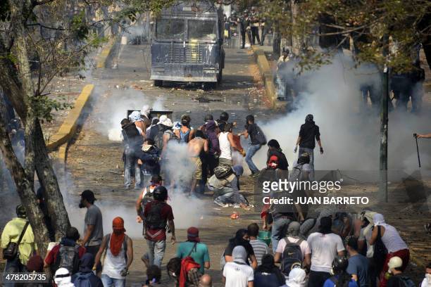 Venezuelan students clash with riot police during a protest against the government of President Nicolas Maduro, in Caracas on March 12, 2014. A young...