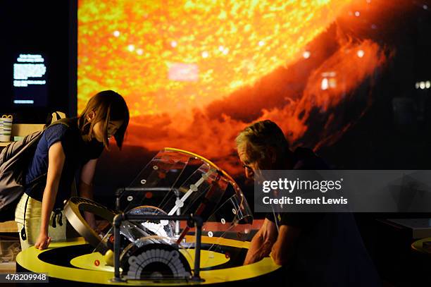 Volunteer David Bauer shows off a sun dial to Lily Cole in the Space Odyssey exhibition on Tuesday, June 23, 2015 at the Denver Museum of Nature and...