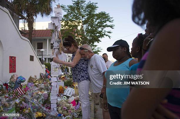 Steve Kent hugs his wife Kim visit the memorial outside Emanuel AME Church in Charleston, South Carolina, on June 23, 2015. Police captured the white...