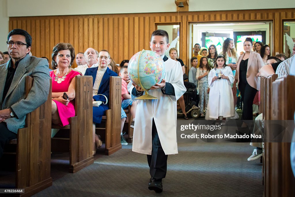 Catholic First Communion Ceremony: Adolescent boy carrying...