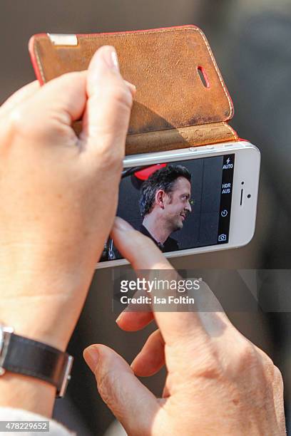 Guest takes a picture with a smartphone of Till Broenner during the vernissage 'Flash by Lenny Kravitz' on June 23, 2015 in Wetzlar, Germany.