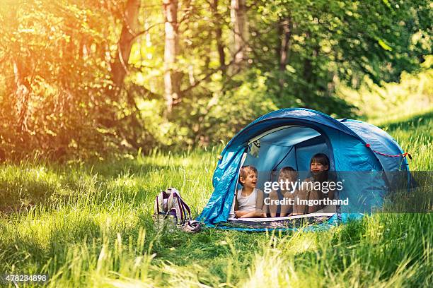 hiker kids sitting in tent in the forest - the tent stockfoto's en -beelden