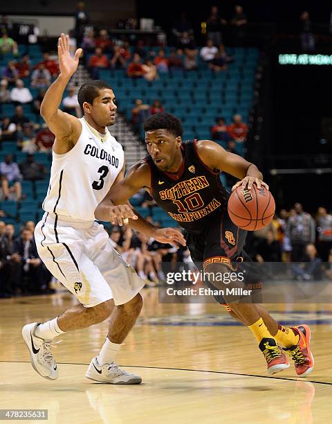 Pe'Shon Howard of the USC Trojans drives against Xavier Talton of the Colorado Buffaloes during a first-round game of the Pac-12 Basketball...