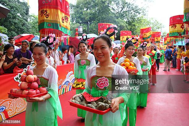 Girls carry edible tributes during the birthday celebration of "Mother of Dragons" near Yellow Bamboo Hill on June 23, 2015 in Foshan, Guangdong...