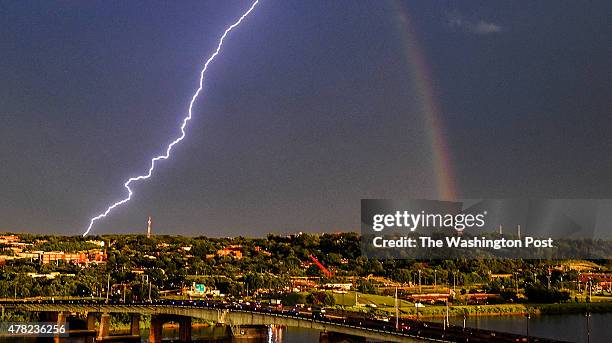 Bolt of lightning strikes across the Anacostia river as a rainbow graces the sky near Nationals Park as the Washington Nationals and Atlanta Braves...