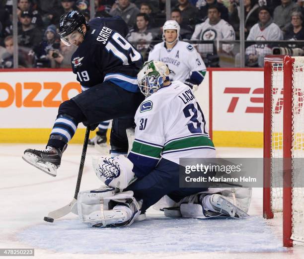 Jim Slater of the Winnipeg Jets tries to get the puck past Eddie Lack of the Vancouver Canucks in second-period action in an NHL game at the MTS...