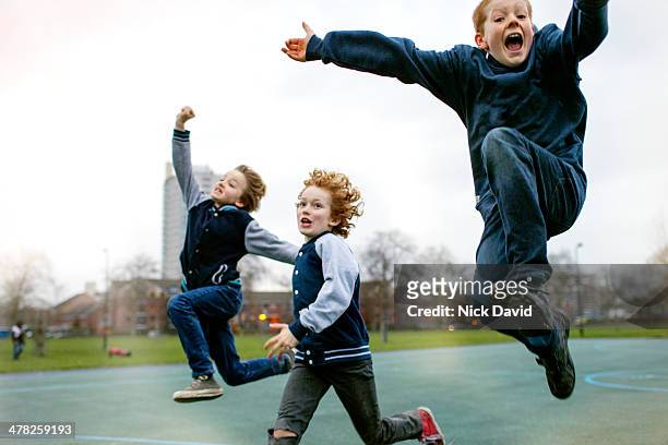 children playing in park - kindertijd stockfoto's en -beelden