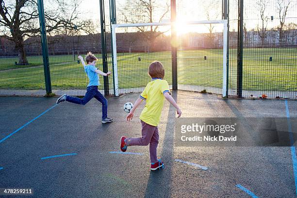 boys playing football - football player stock-fotos und bilder