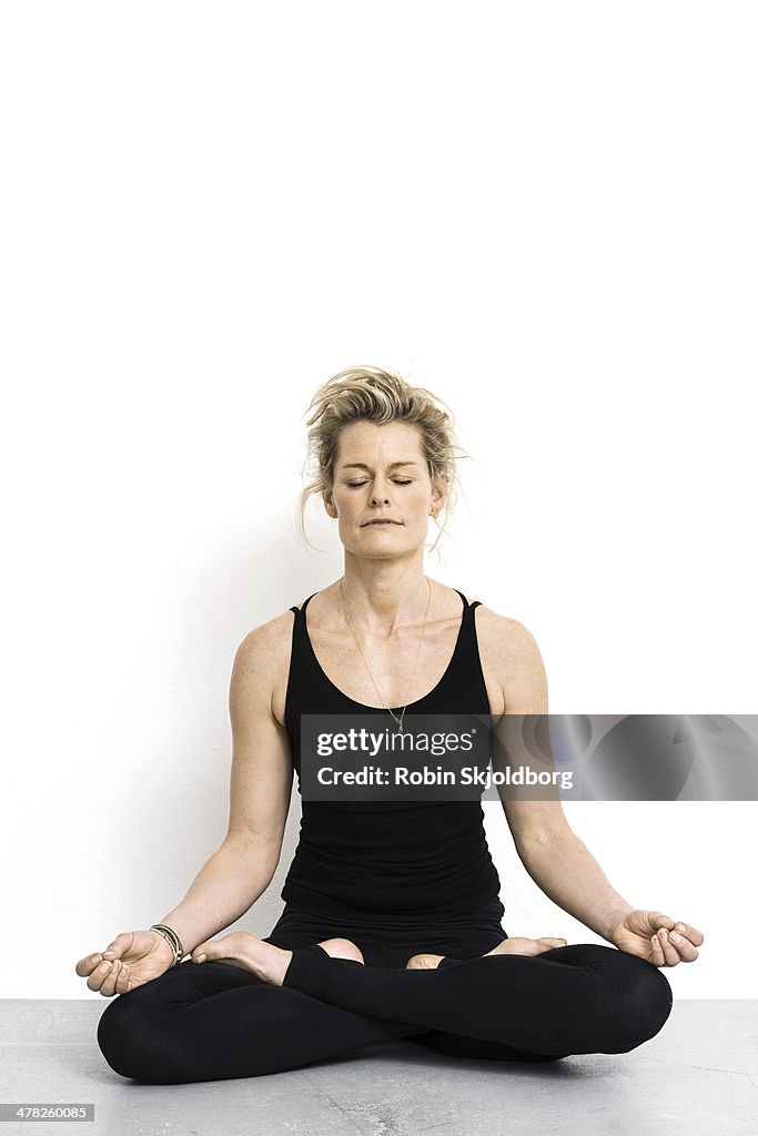 Woman with eyes closed sitting in lotus position