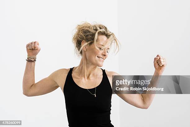 woman in tank top stretching her arms and smiling - dancing white background stock pictures, royalty-free photos & images
