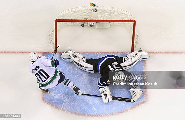 Chris Higgins of the Vancouver Canucks scores the shootout winner over a sprawling Ondrej Pavelec of the Winnipeg Jets at the MTS Centre on March 12,...