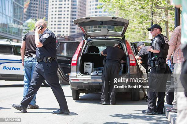 Police investigate inside of a car in front of John Joseph Moakley United States Courthouse after a man was taken into custody who had a meat cleaver...