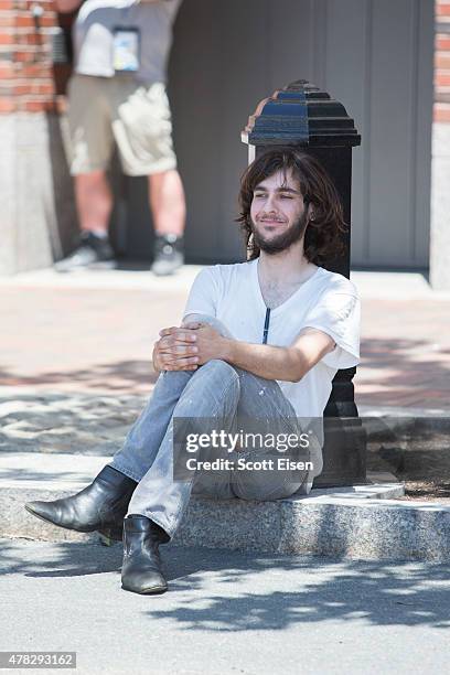 Man sits while police search his car after they found a meat cleaver in it in front of John Joseph Moakley United States Courthouse during the formal...