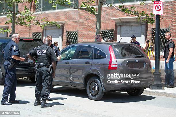 Police investigate inside of a car in front of John Joseph Moakley United States Courthouse after a man was taken into custody who had a meat cleaver...