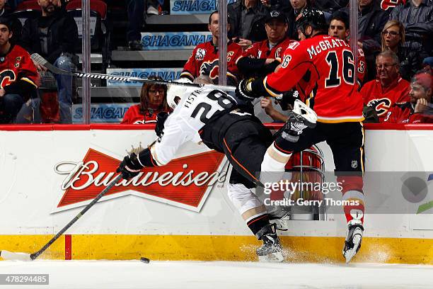 Brian McGrattan of the Calgary Flames checks Mark Fistric of the Anaheim Ducks at Scotiabank Saddledome on March 12, 2014 in Calgary, Alberta, Canada.