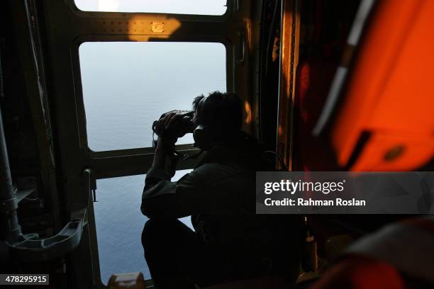 Sgt. Zulhelmi Hassan of the Malaysian Air Forces searches the water for signs of debris from the Malaysian airliner during a search and rescue...