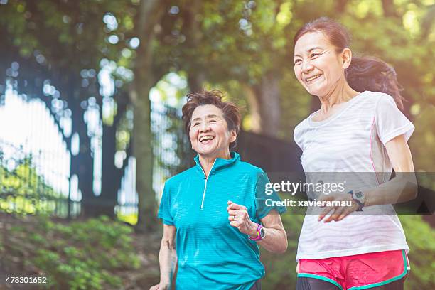 senior women running in yoyogi park - active seniors asian stock pictures, royalty-free photos & images