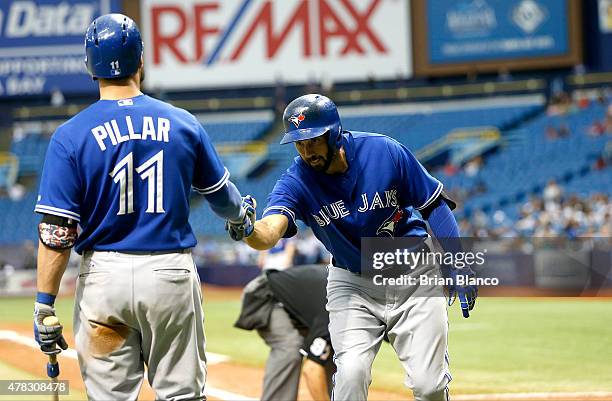 Chris Colabello of the Toronto Blue Jays celebrates with teammate Kevin Pillar following his home run on line drive to center field off of pitcher...