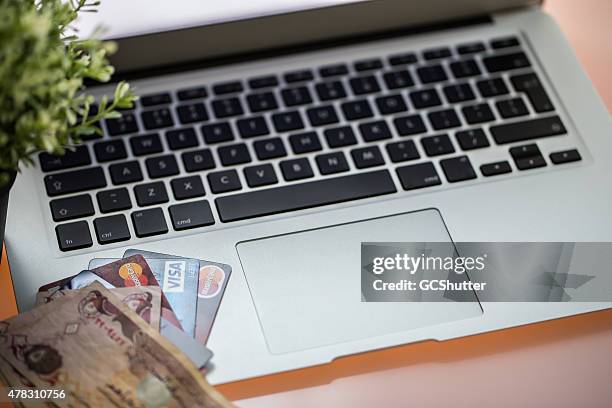 macbook air with credit cards and currency notes - touchpad bildbanksfoton och bilder