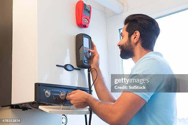 engineer servicing central heating boiler - boiler stockfoto's en -beelden