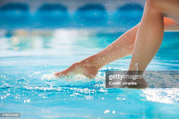 woman's feet splashing the pool water - pool feet stock pictures, royalty-free photos & images