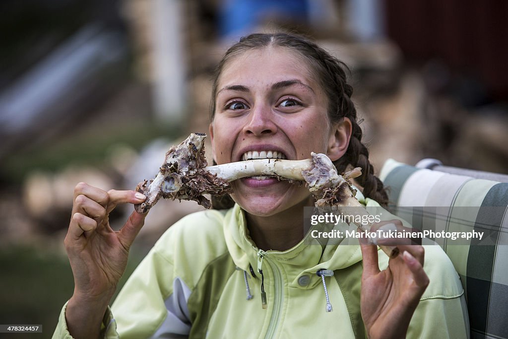 Woman eating meat off a bone