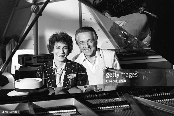 Portrait of Marie Paule BELLE and Jean Pierre CASSEL sat behind a piano for the program ""Show"".
