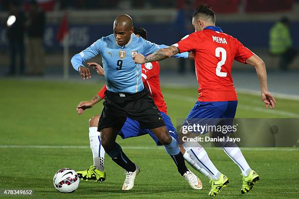 Diego Rolan of Uruguay fights for the ball with Eugenio Mena of Chile during the 2015 Copa America Chile quarter final match between Chile and...