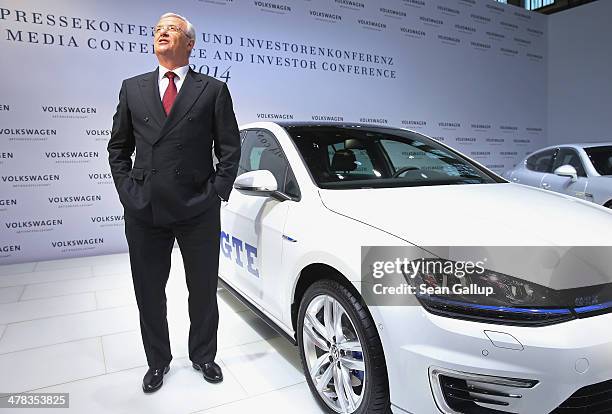 Martin Winterkorn, Chariman of the German carmaker Volkswagen AG, stands next to a VW GTE as he arrives for the company's annual press conference to...