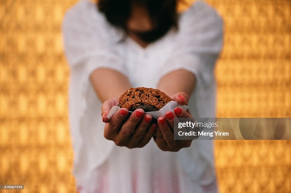 Chocolate muffin in girl's hand