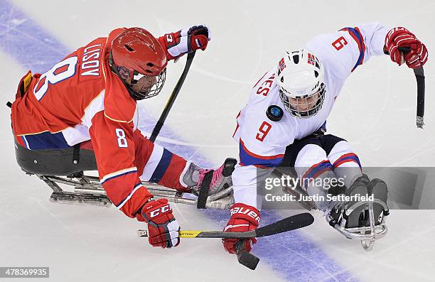 Morten Vaernes of Norway gets the puck caught on his shoulder during a challenge with Dmitirii Lisov of Russia during the Ice Sledge Hockey play off...
