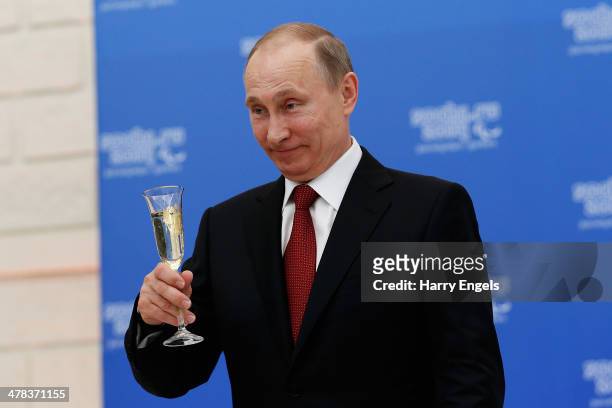 Russian President Vladimir Putin holds a glass of champagne during a lunch hosted by the office of the Russian President Vladimir Putin for the...