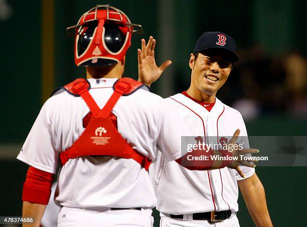 Koji Uehara of the Boston Red Sox is congratulated by Sandy Leon of the Boston Red Sox after the Red Sox 5-1 win over the Baltimore Orioles in a game...