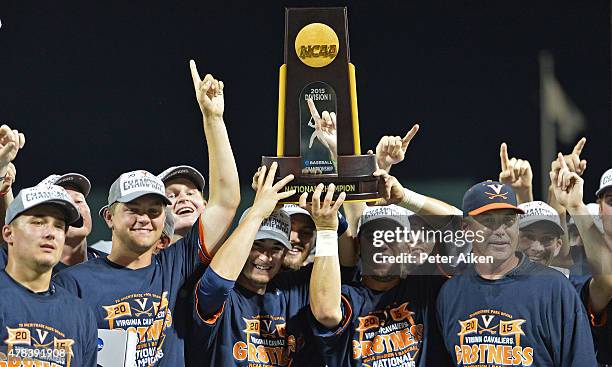 Players and coaches of the Virginia Cavaliers hold up the National Championship trophy after defeating the Vanderbilt Commodores during game three of...