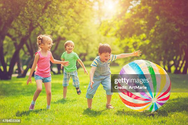 little girl and boys playing with ball - beach ball stock pictures, royalty-free photos & images