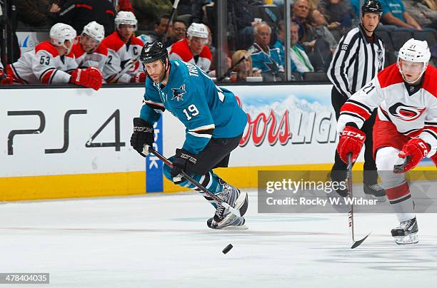 Joe Thornton of the San Jose Sharks skates after the puck against Drayson Bowman of the Carolina Hurricanes at SAP Center on March 4, 2014 in San...