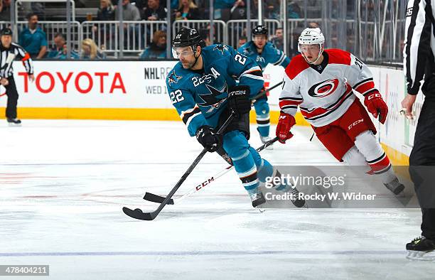 Dan Boyle of the San Jose Sharks skates with control of the puck against Drayson Bowman of the Carolina Hurricanes at SAP Center on March 4, 2014 in...