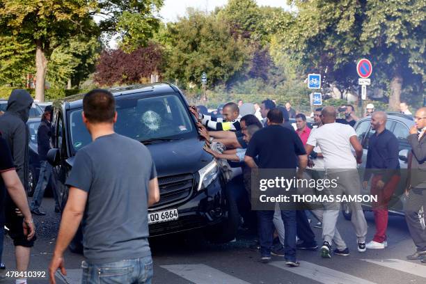 Demonstrators try to turn over an alleged minicab, known in France as VTC , at Porte Maillot in Paris on June 25 as hundreds of taxi drivers...