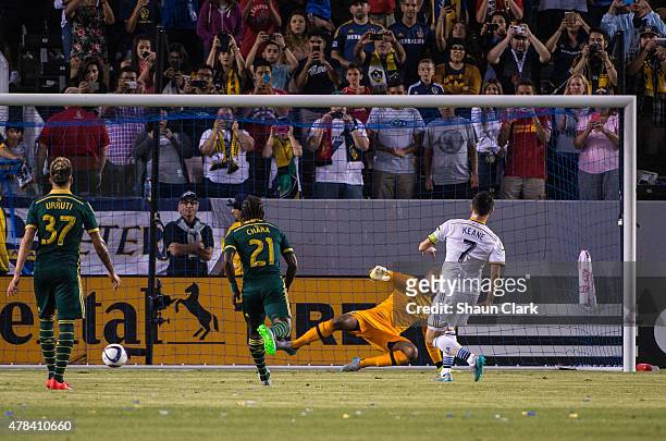 Robbie Keane of Los Angeles Galaxy scores on a penalty kick as Adam Kwarasey of Portland Timbers goes the wrong direction during Los Angeles Galaxy's...