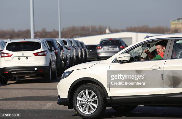 An employee unloads a new Nissan Qashqai SUV automobile, produced by Nissan Motor Co., from a car transporter at the Port of Tyne, South Shields,...