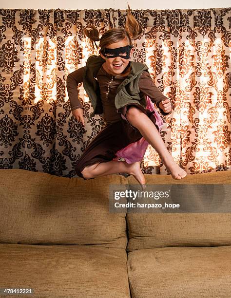 superhero girl jumping on sofa - child superhero shadow stock pictures, royalty-free photos & images